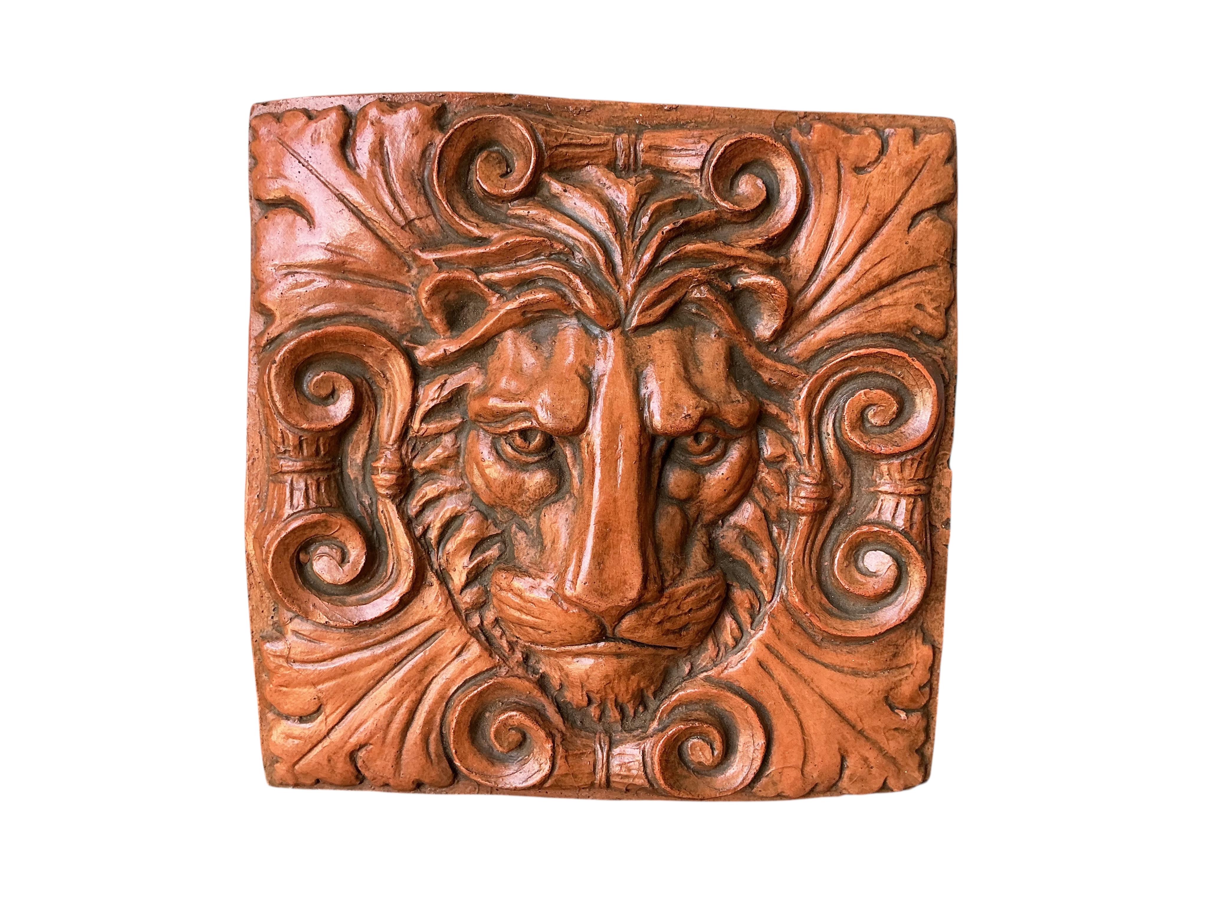 A terracotta lion mask garden wall tile, width 29cm, height 30cm